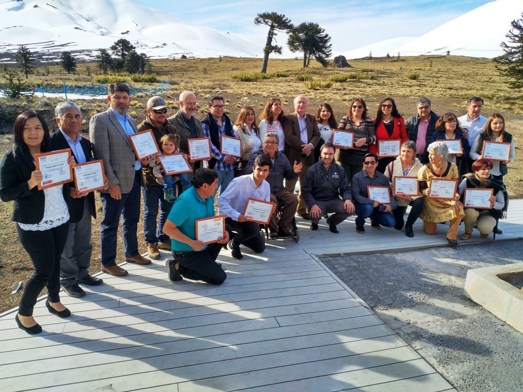 Representantes de las 23 empresas turísticas de La Araucanía Andina que fueron distinguidas con el programa de Gestión Organizacional de Sernatur, con sus diplomas entre araucarias y volcanes nevados en Corralco